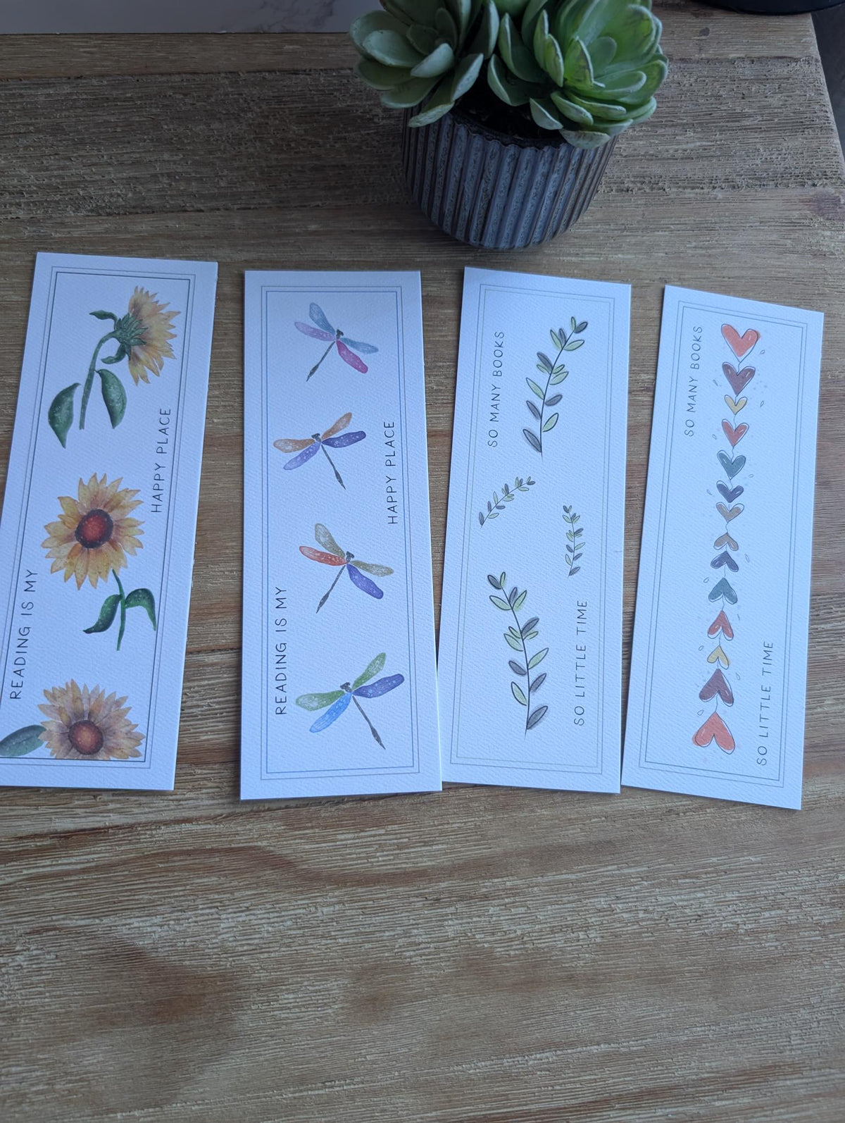 image of four bookmarks on a wood table with varying designs