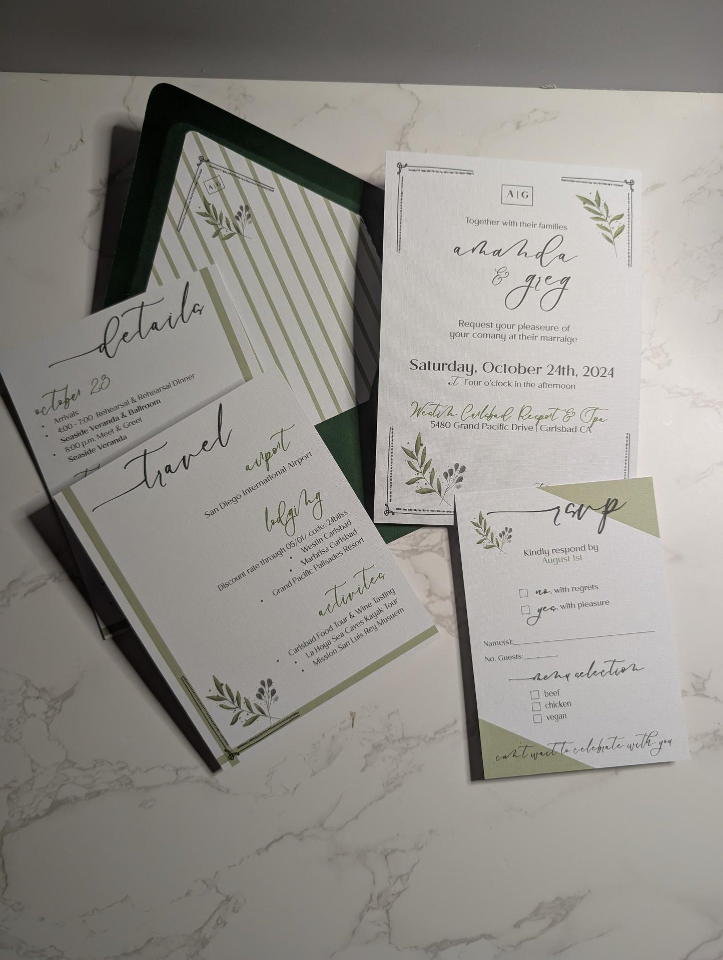 Wedding invitation set with greenery design on a marble surface