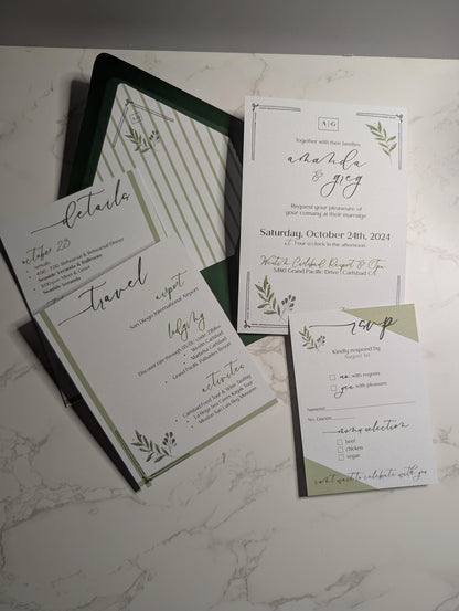Wedding invitation set with greenery design on a marble surface