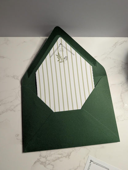 Green envelope with a white striped card on a marble surface