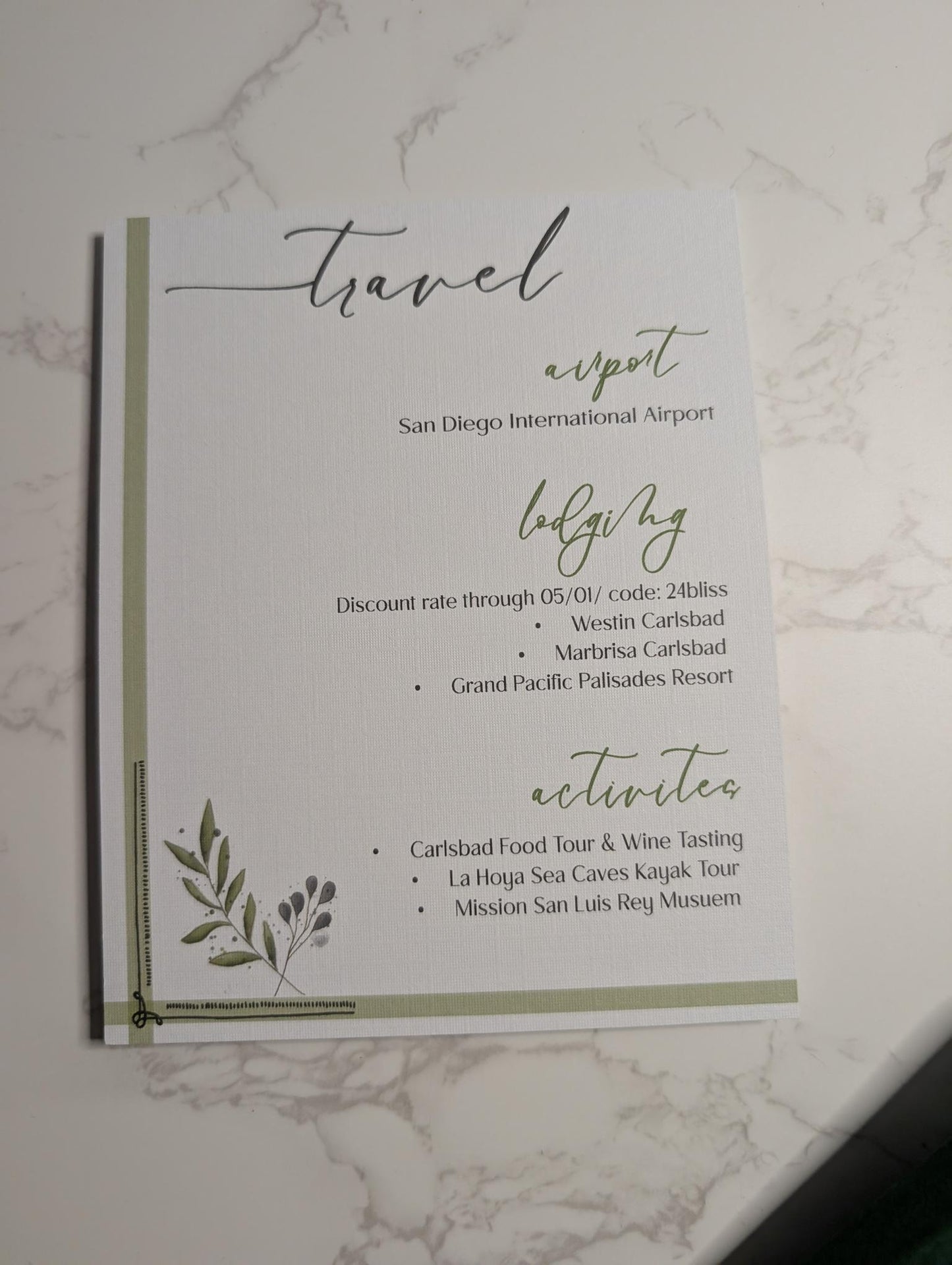 Travel itinerary card for San Diego International Airport with green accents on a marble surface