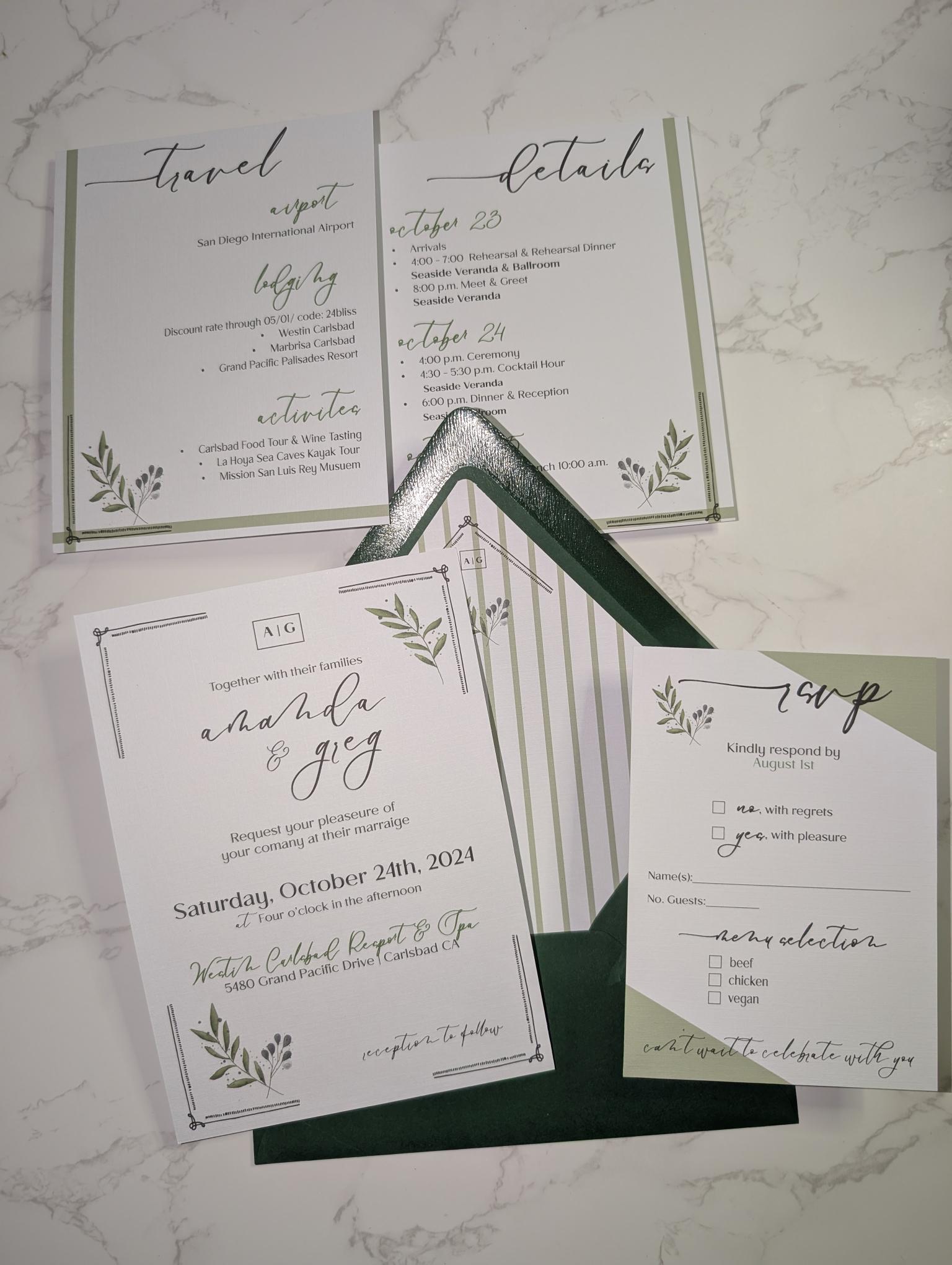 Wedding invitation set with greenery design on a marble surface