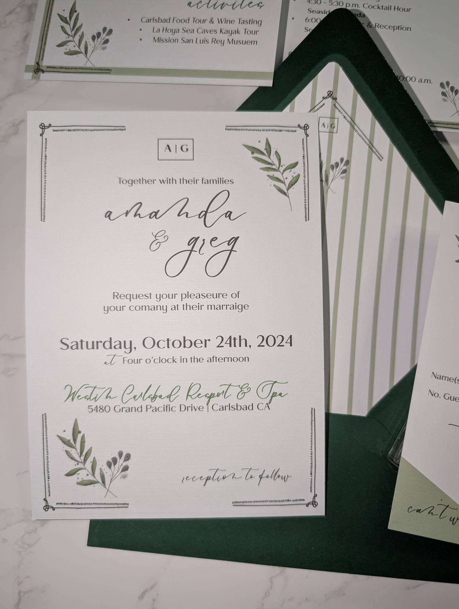Wedding invitation card with greenery design on a marble surface