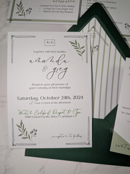 Wedding invitation card with greenery design on a marble surface