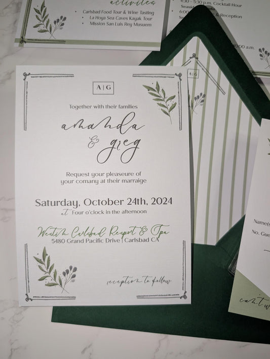 Wedding invitation card with greenery design on a marble surface