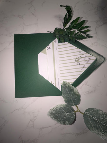 Green card with a cut-out design on a marble surface