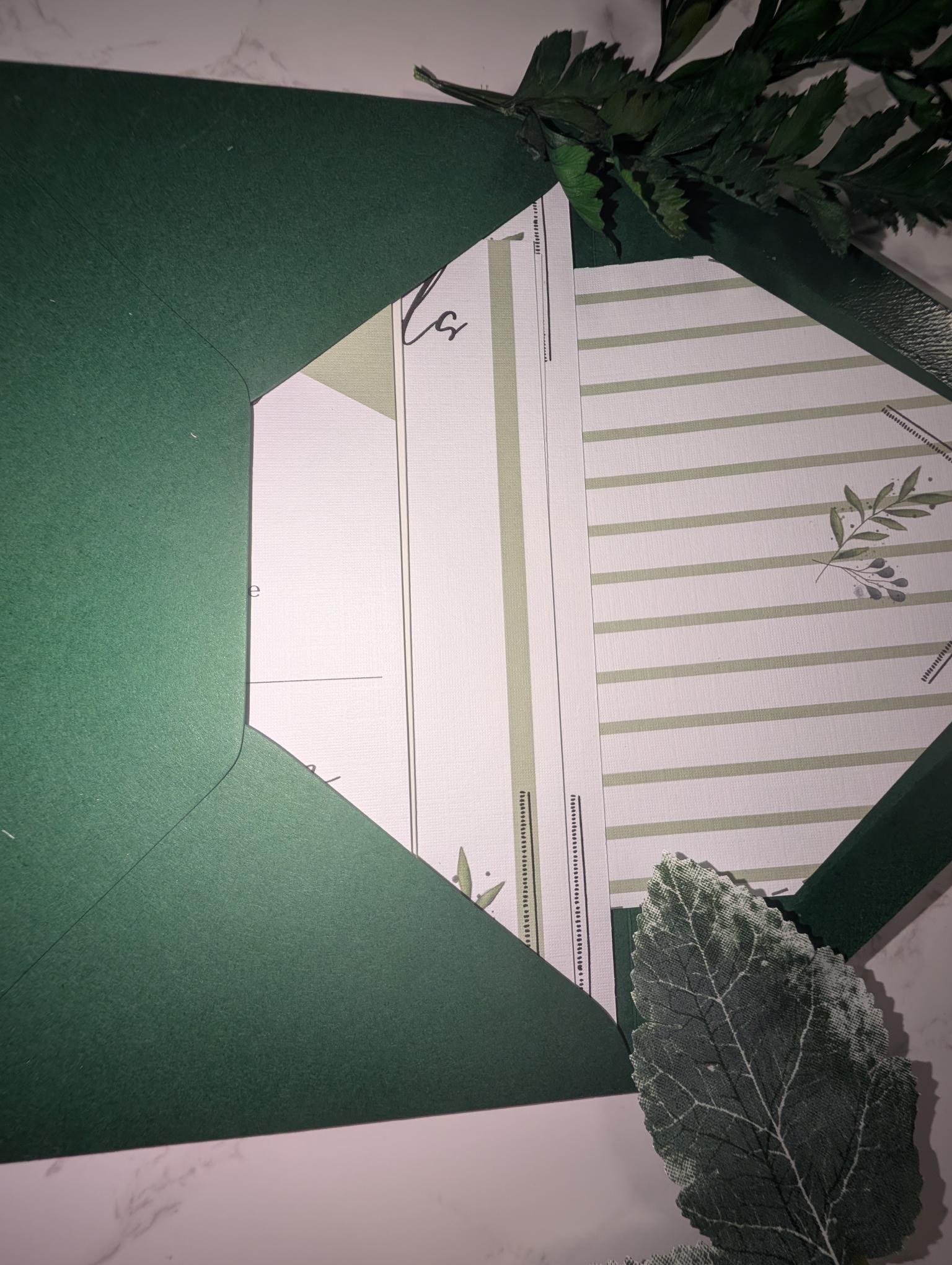 Close-up of a green card with a white envelope and decorative elements on a green background.