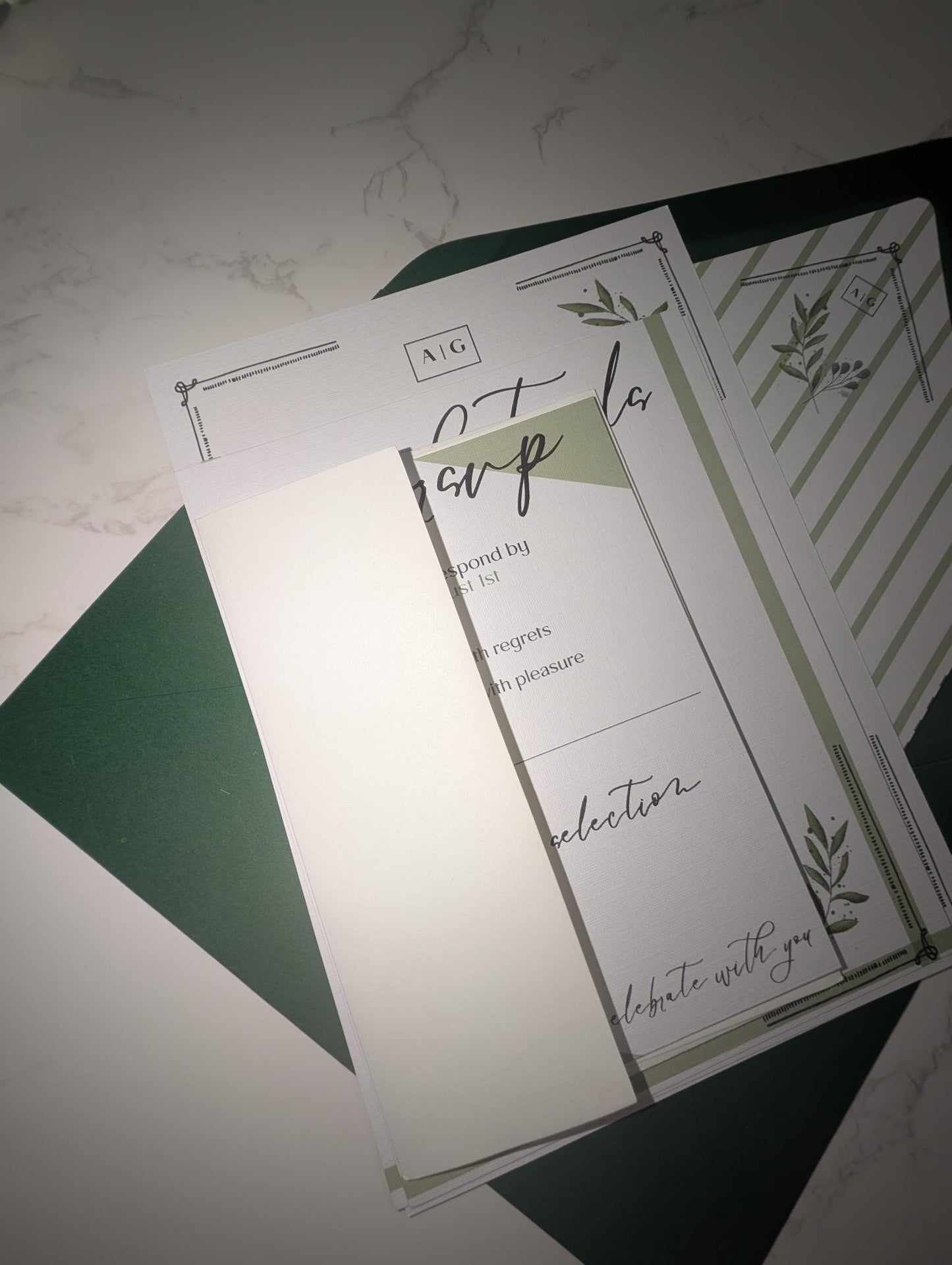 Set of stationery items with green and white design on a textured surface