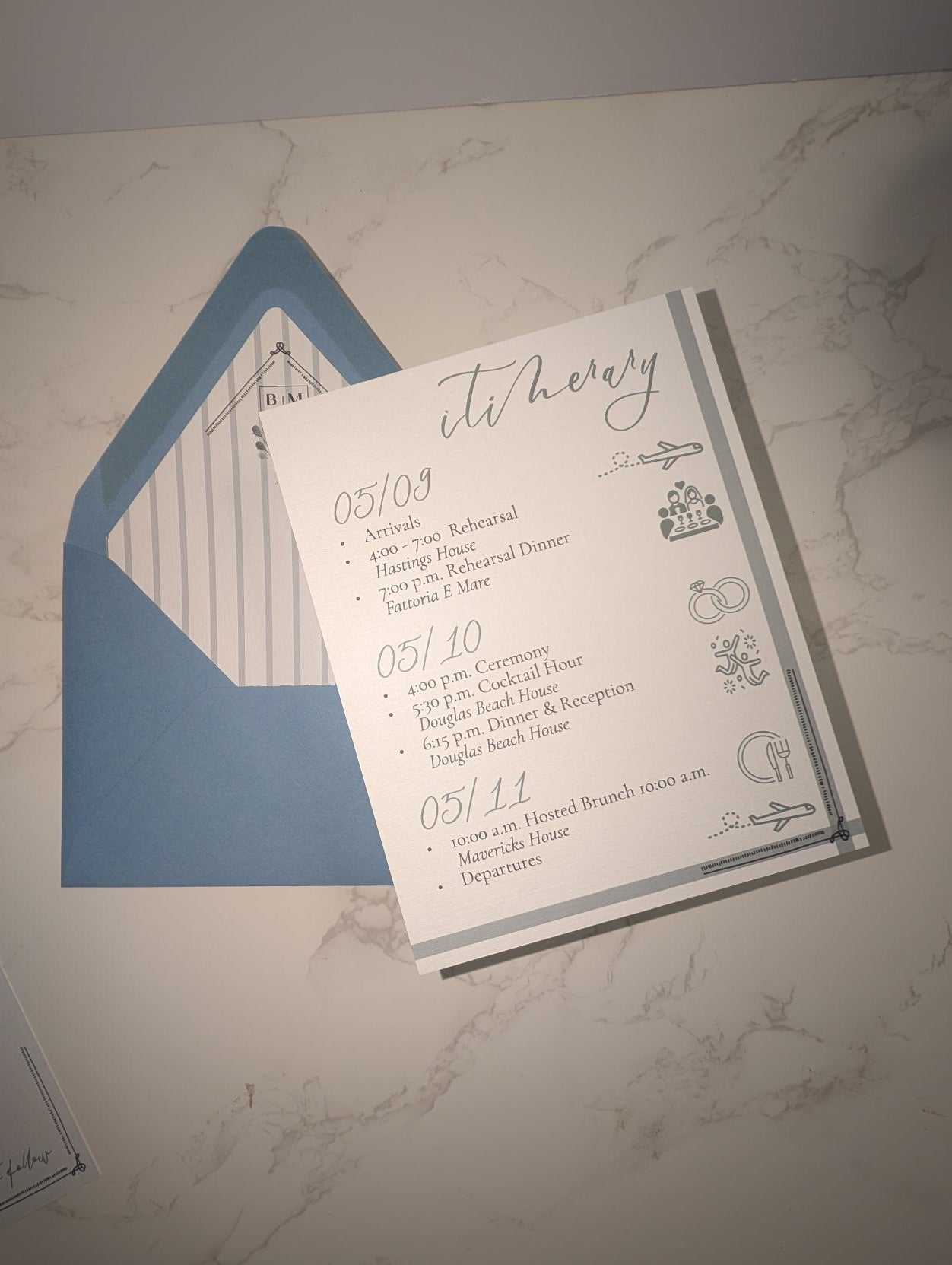 Wedding invitation with blue envelope on a marble surface