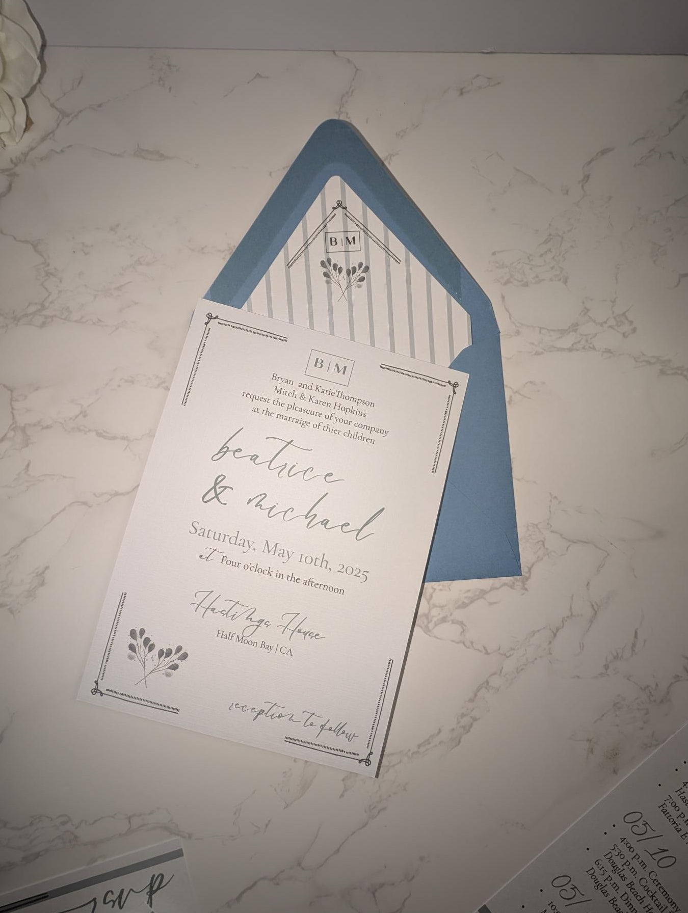 Wedding invitation card with blue envelope on a marble surface