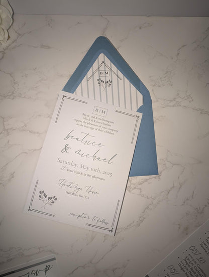 Wedding invitation card with blue envelope on a marble surface