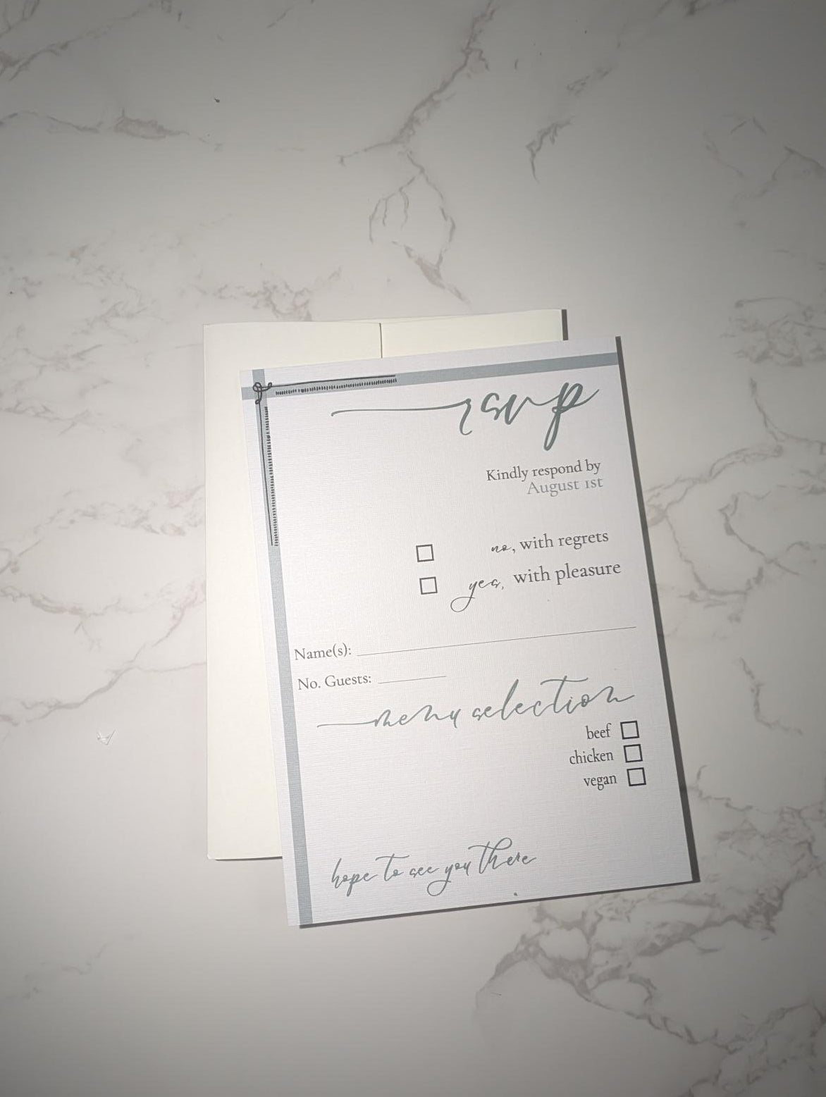 RSVP card with checkboxes on a marble surface