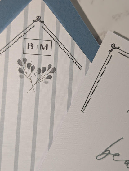 Notebook with floral design and initials on a textured surface