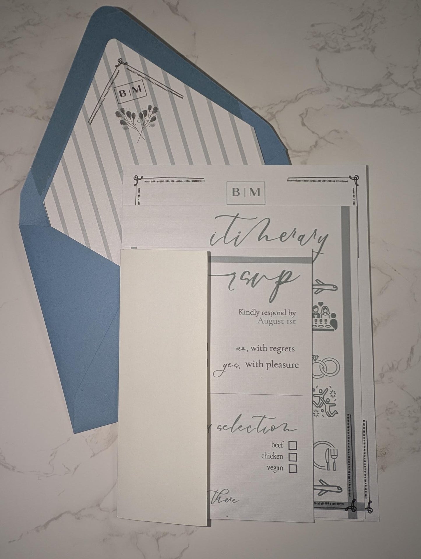 Invitation card with blue envelope on a marble surface