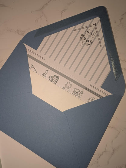 Blue envelope with a beige interior featuring text and designs on a marble surface