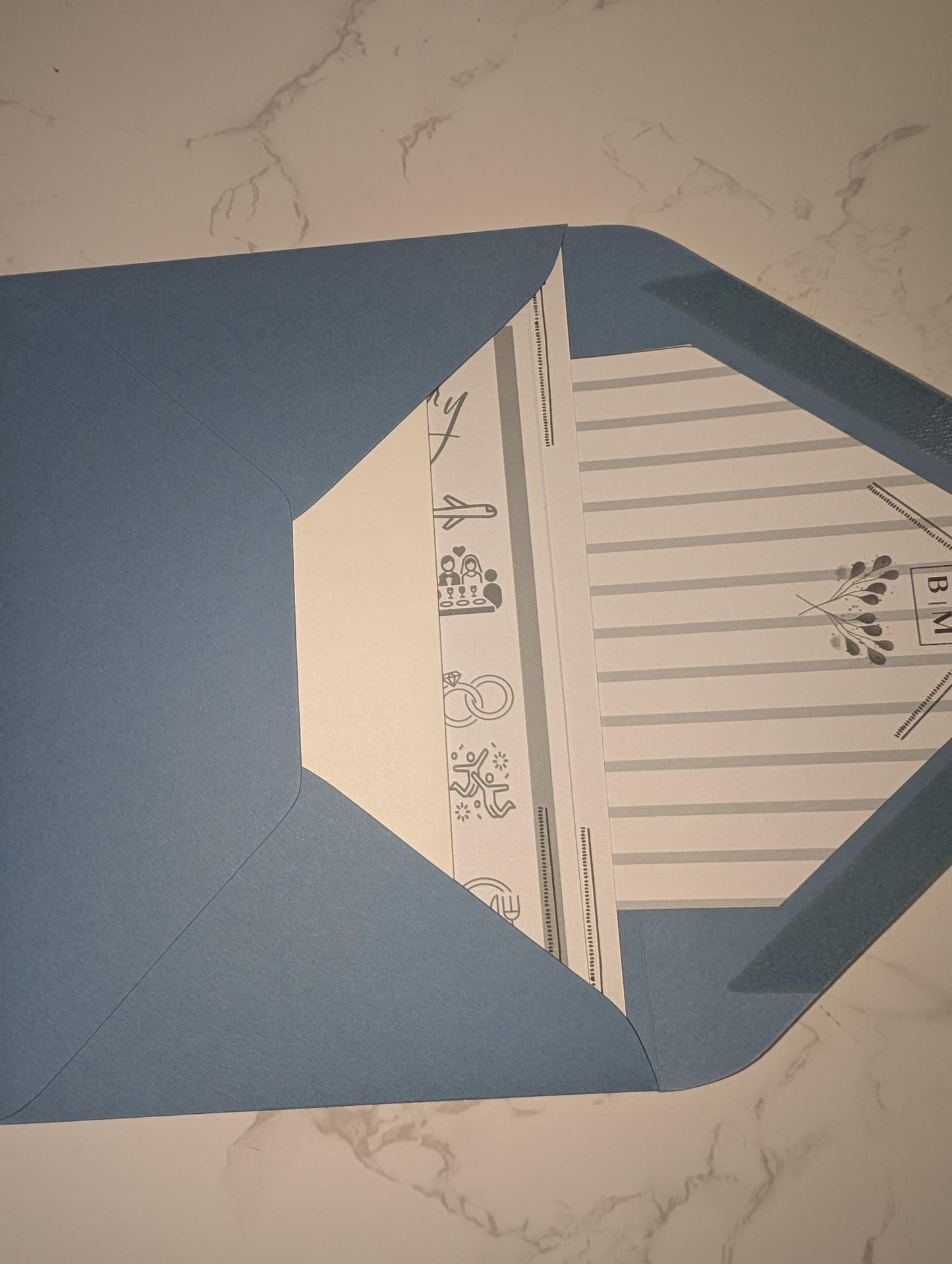 Blue envelope with a white interior design on a marble surface