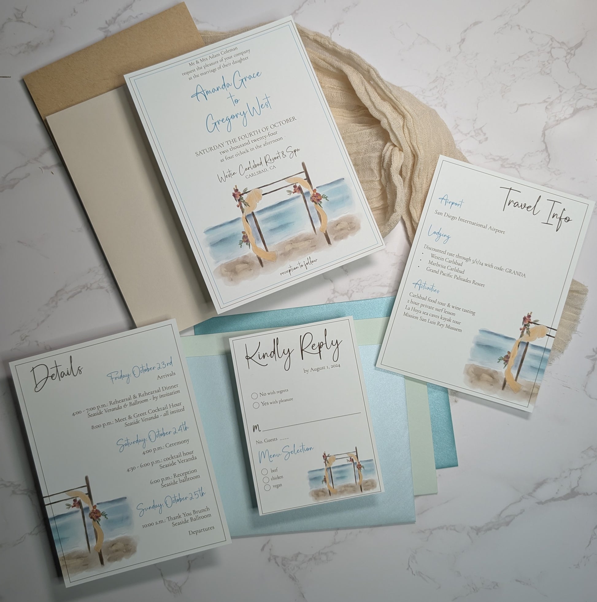 Set of beach-themed wedding invitations on a marble surface