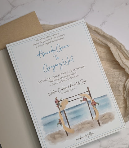 Wedding invitation card with beach scene and swing on a marble surface