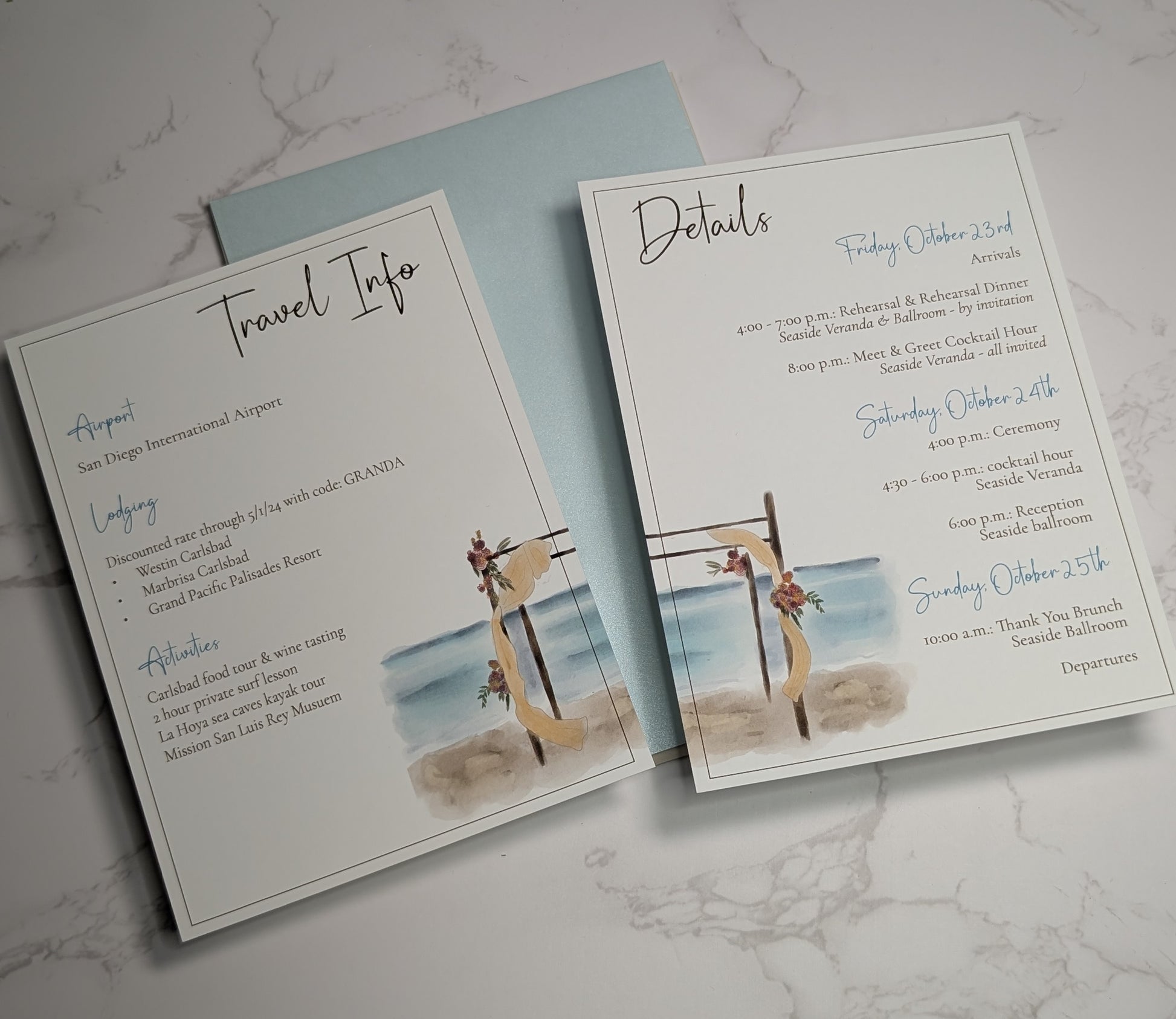 Two wedding invitation cards on a marble surface, one titled 'Travel Info' and the other 'Details'.