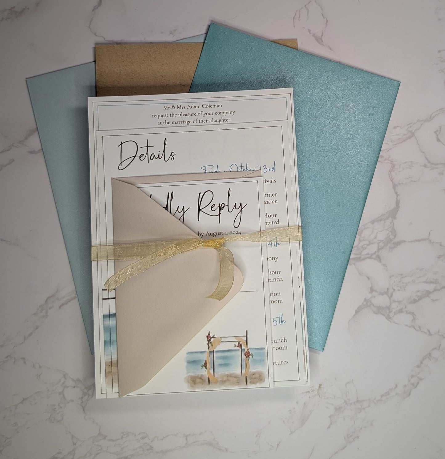 Wedding invitation card with RSVP details on a marble surface