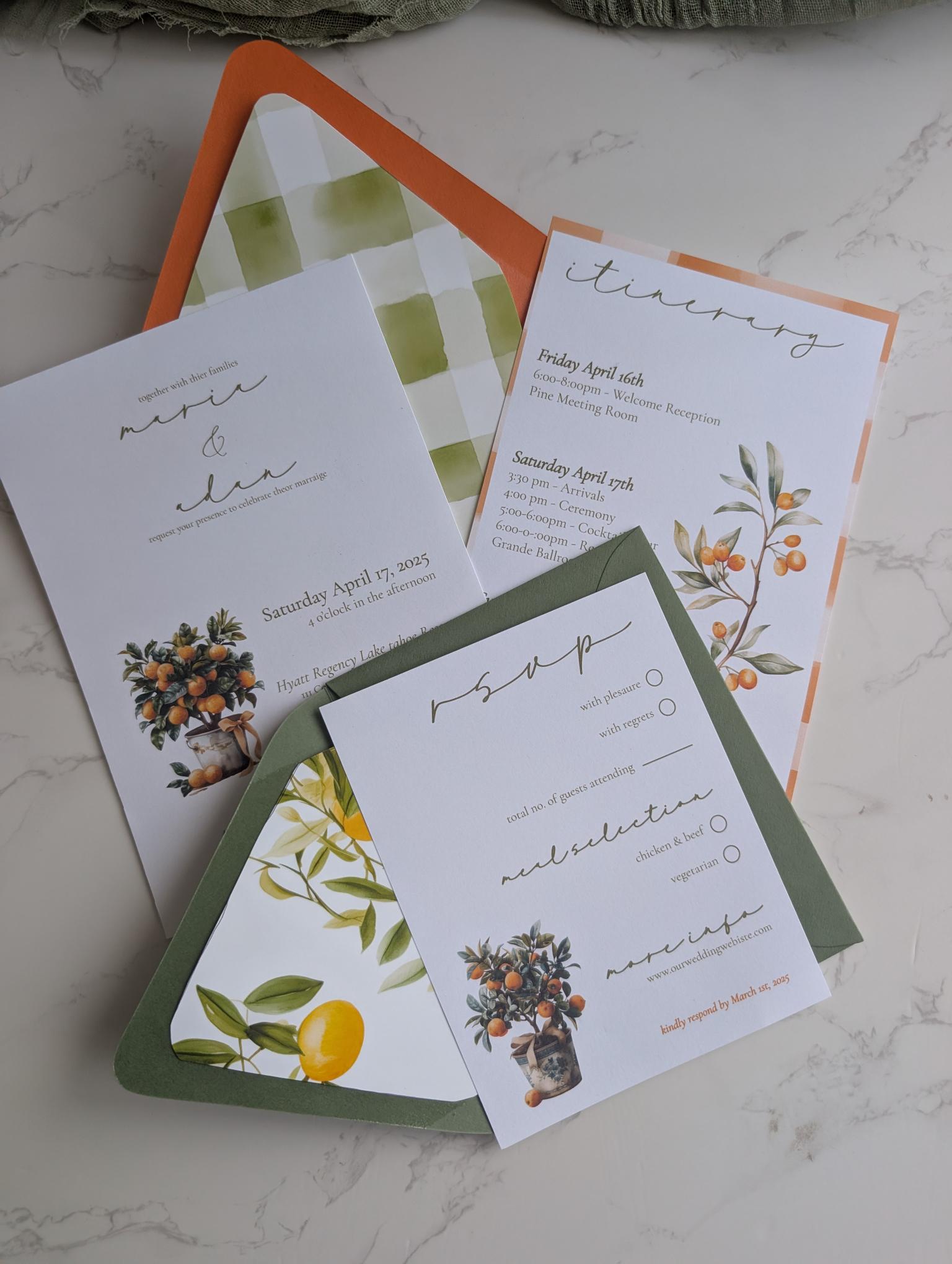 Set of wedding invitations with floral and citrus designs on a marble surface