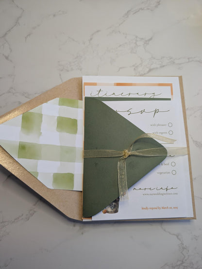 Green envelope with a bow on a white card with text on a marble surface