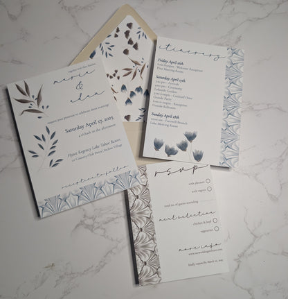Wedding invitation set with floral designs on a marble surface