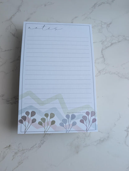 Notepad with floral design on a marble surface