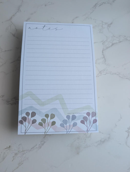 Notepad with floral design on a marble surface