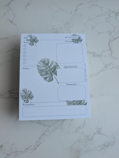 Notepad with plant designs on a marble surface