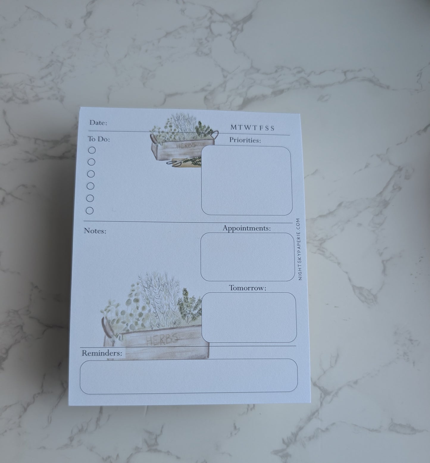 Notebook with plant-themed design on a marble surface