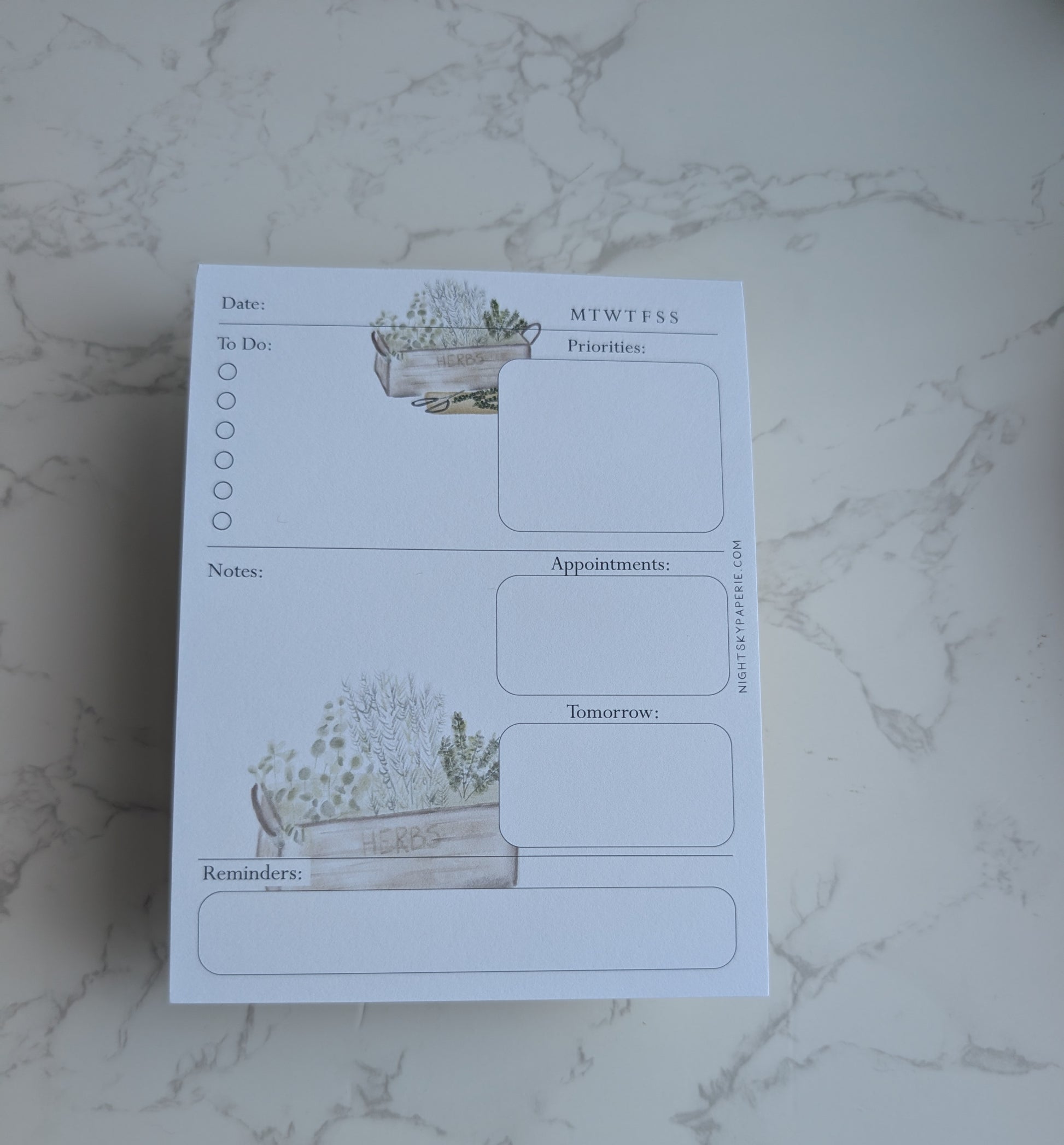 Notebook with plant-themed design on a marble surface