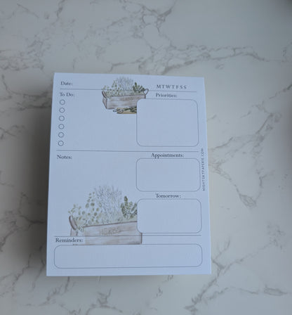 Notebook with plant-themed design on a marble surface