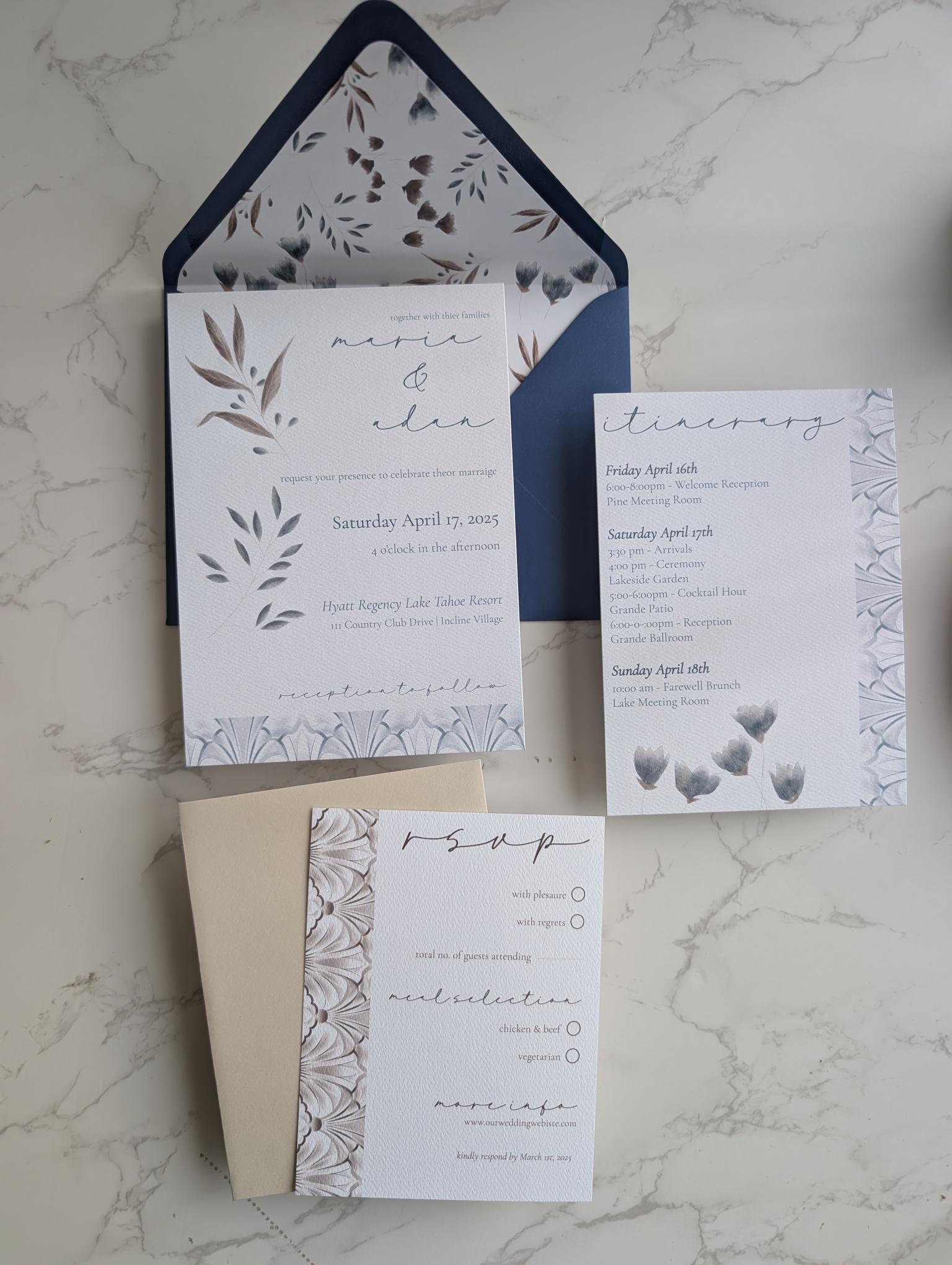 Set of wedding invitations with floral design on a marble surface