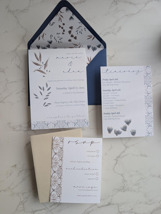Set of wedding invitations with floral design on a marble surface