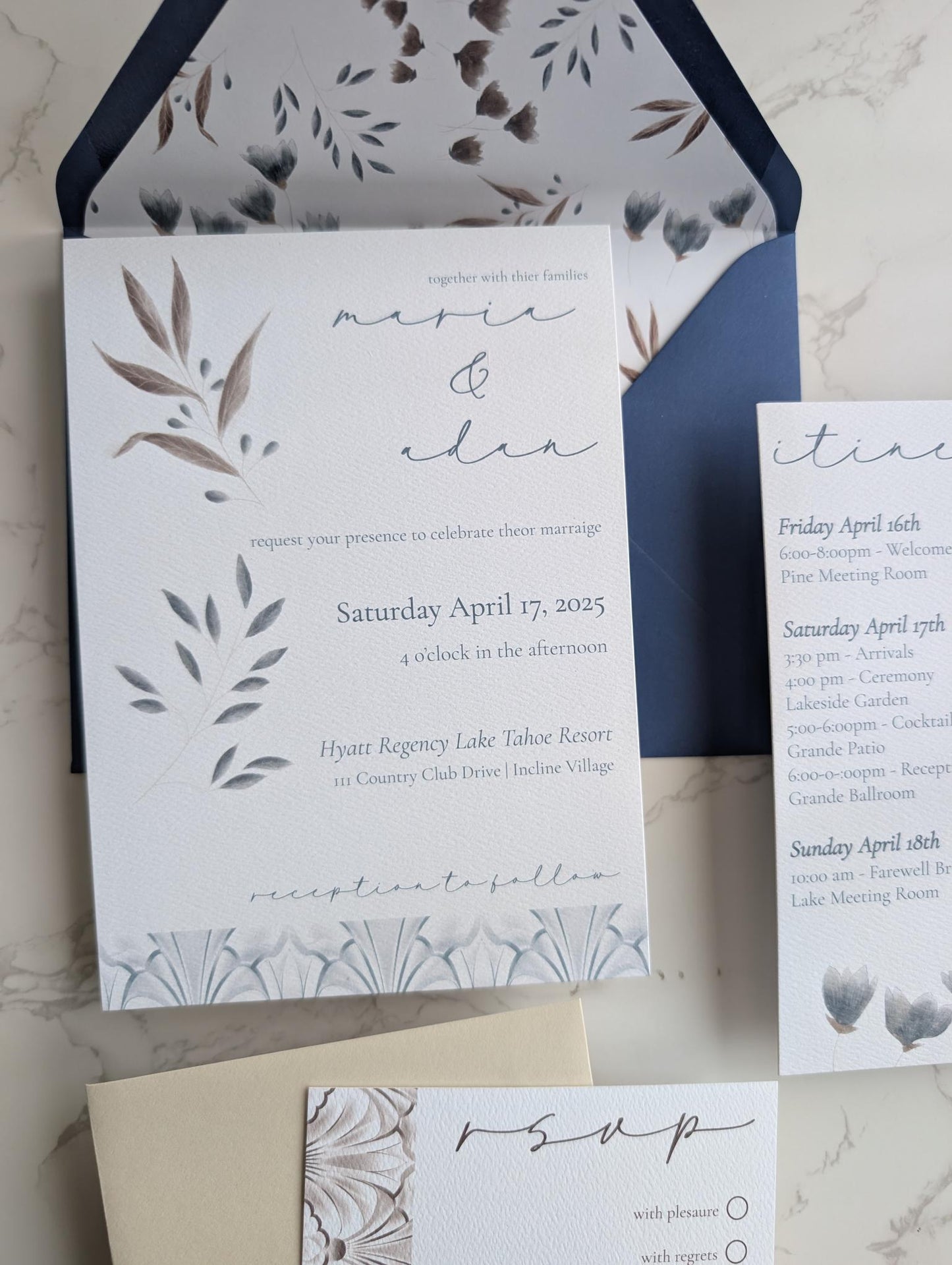 Wedding invitation set with floral design and RSVP card on a marble surface