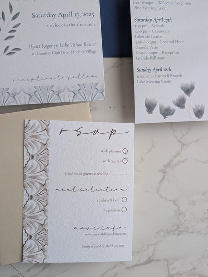 Set of wedding invitations and RSVP card on a marble surface