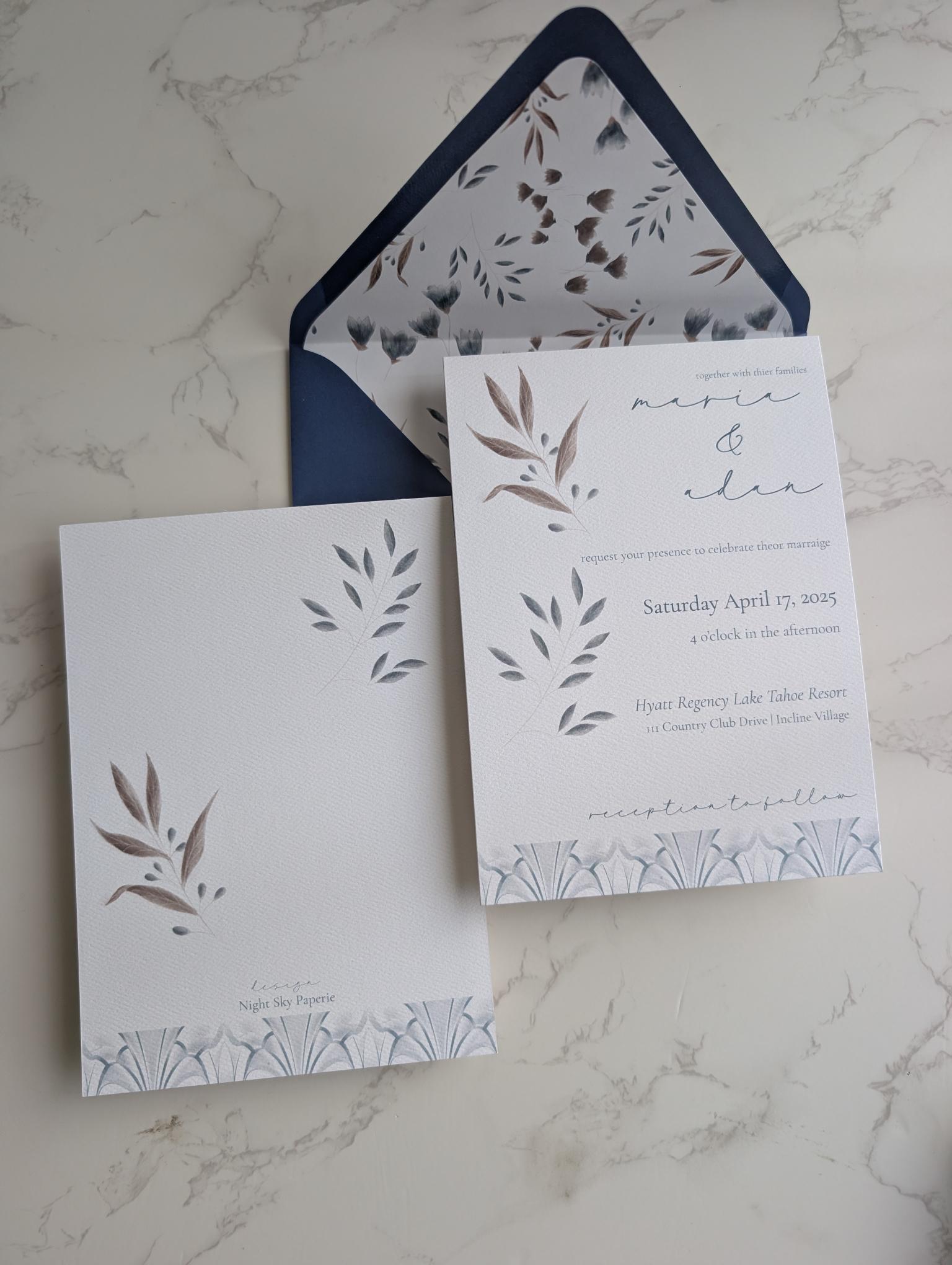 Wedding invitation set with floral design on a marble surface