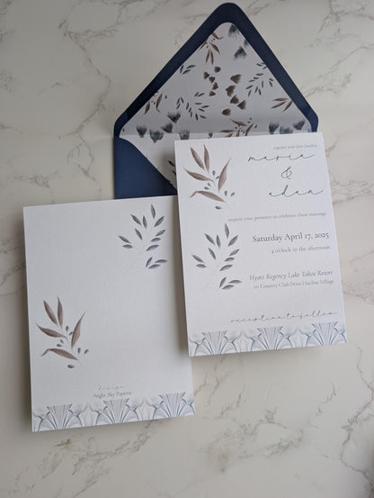 Wedding invitation set with floral design on a marble surface