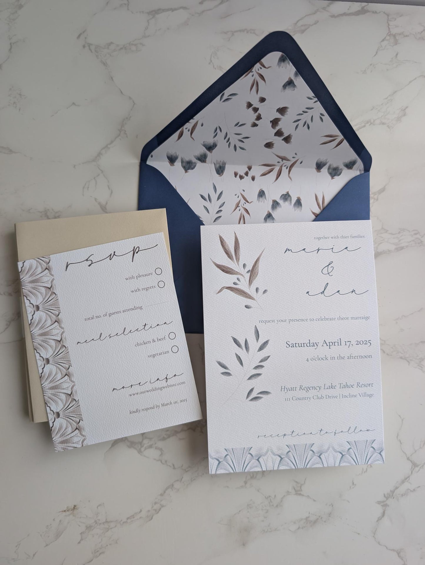 Wedding invitation set with floral design on a marble surface