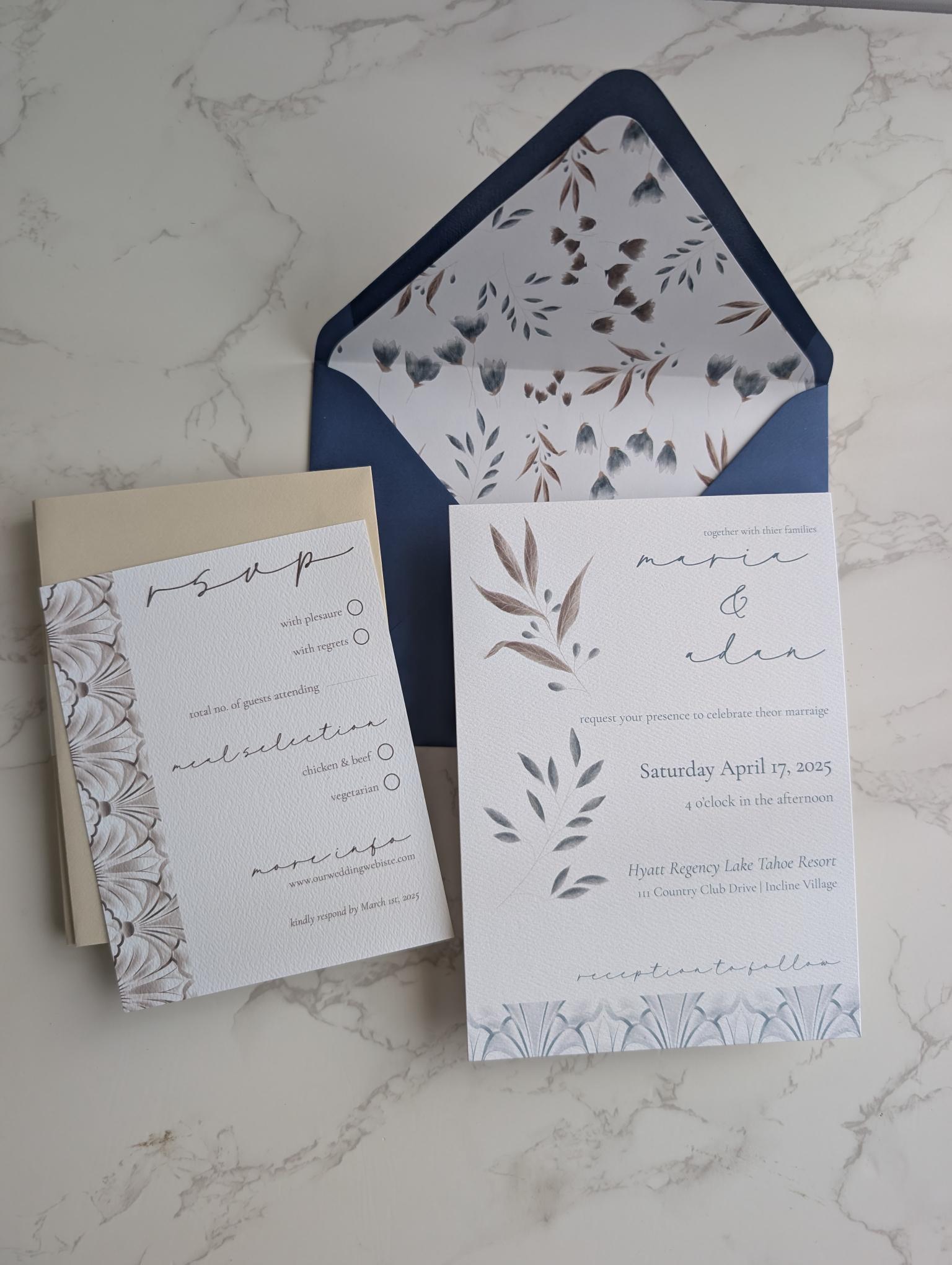 Wedding invitation set with floral design on a marble surface