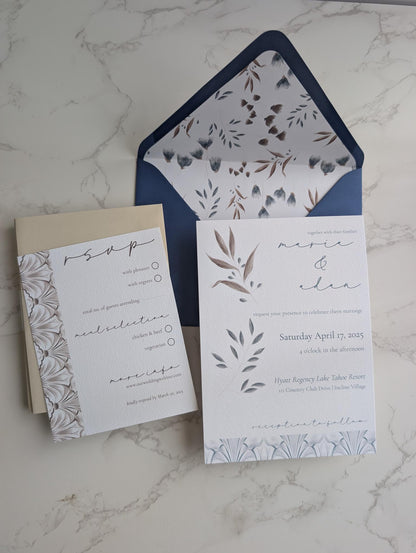 Wedding invitation set with floral design on a marble surface