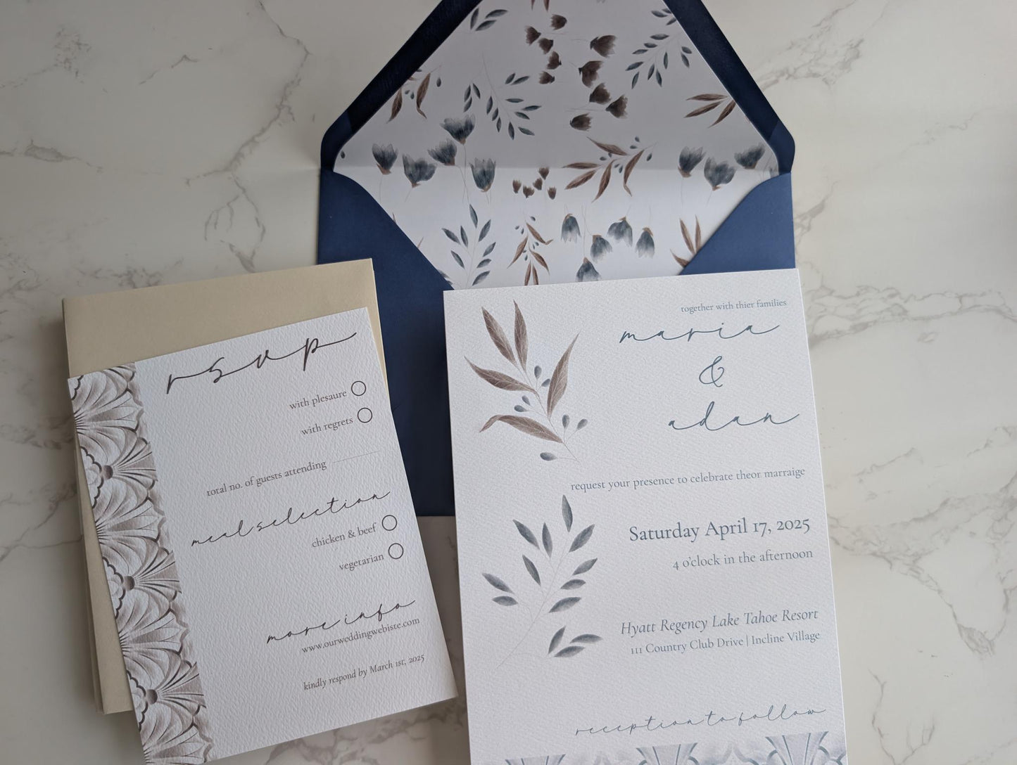 Wedding invitation set with floral design on a marble surface