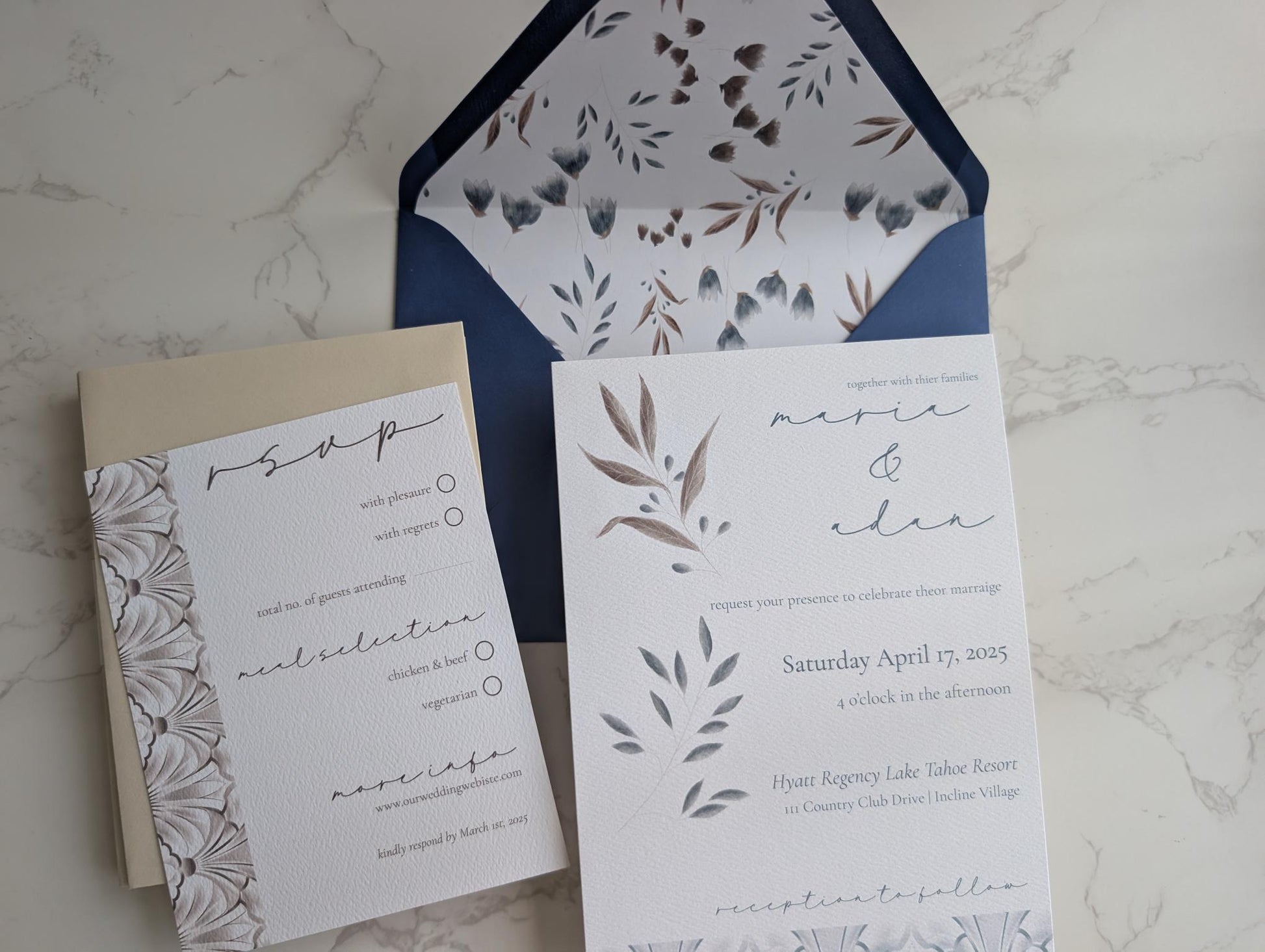 Wedding invitation set with floral design on a marble surface