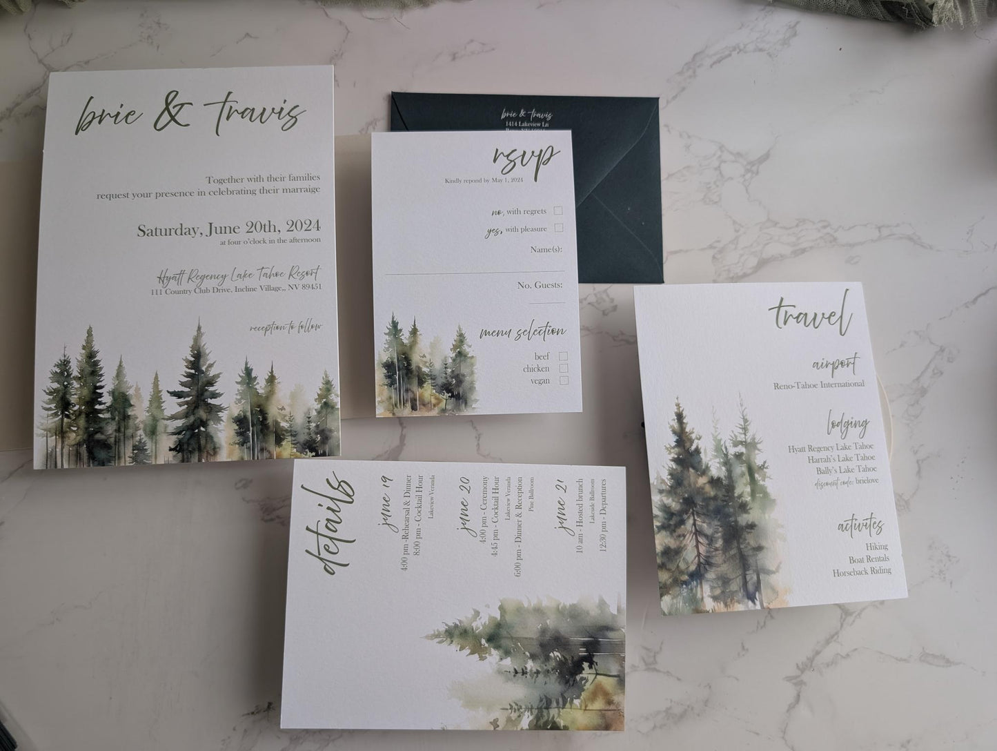 Set of wedding invitations with forest design on a marble surface