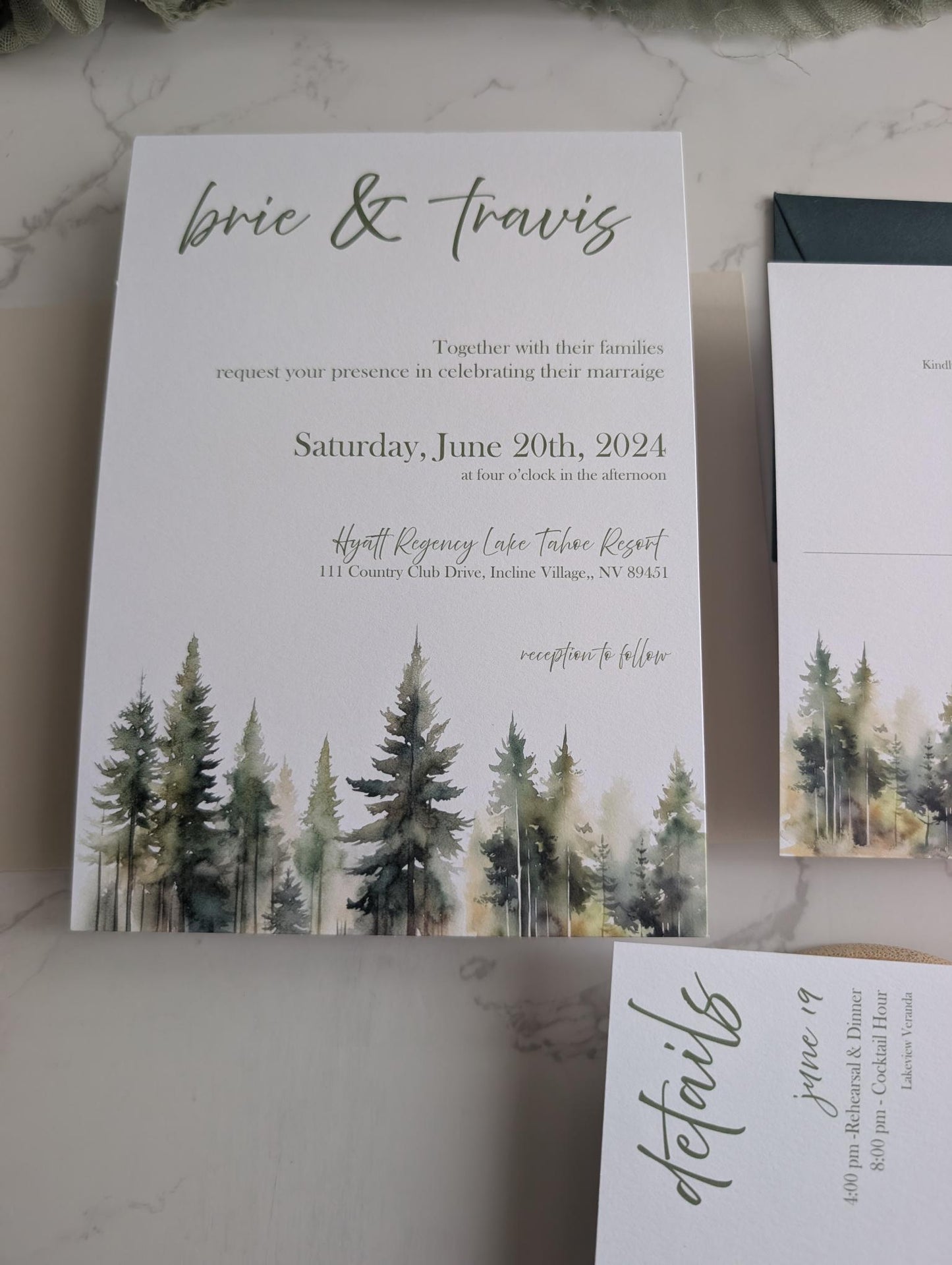 Wedding invitation with forest design and text on a marble surface