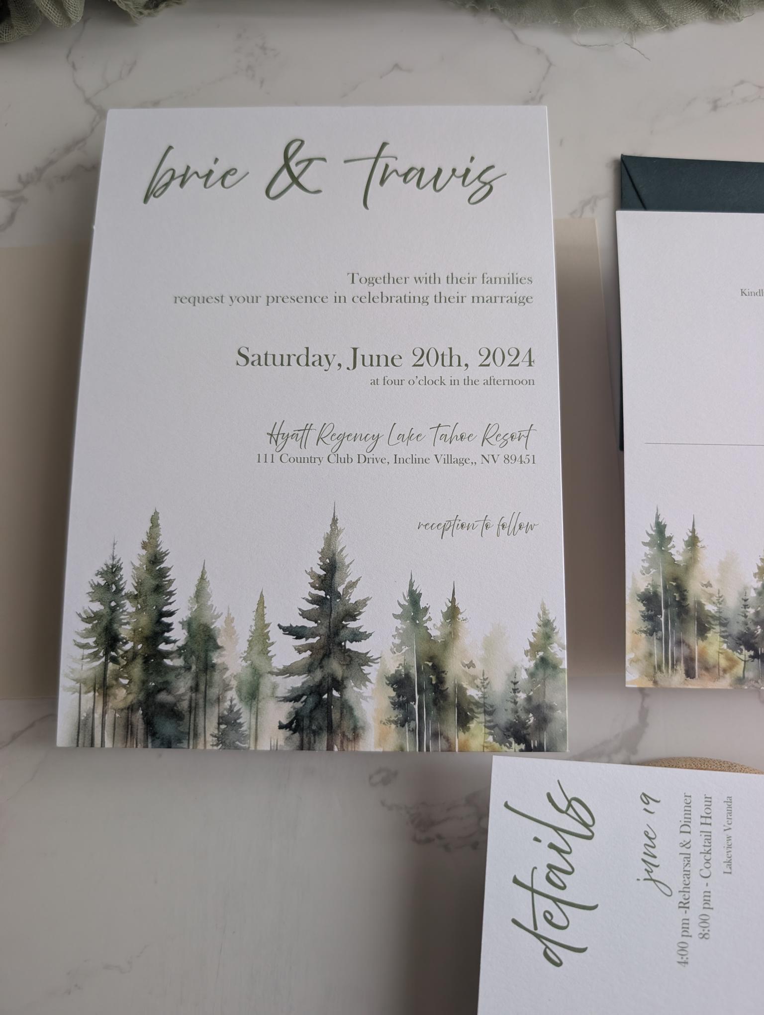 Wedding invitation with forest design and text on a marble surface