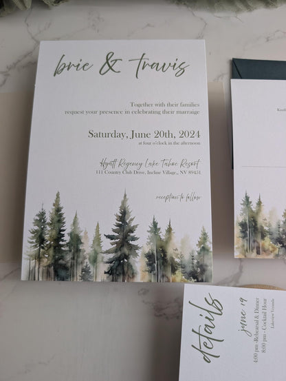 Wedding invitation with forest design and text on a marble surface