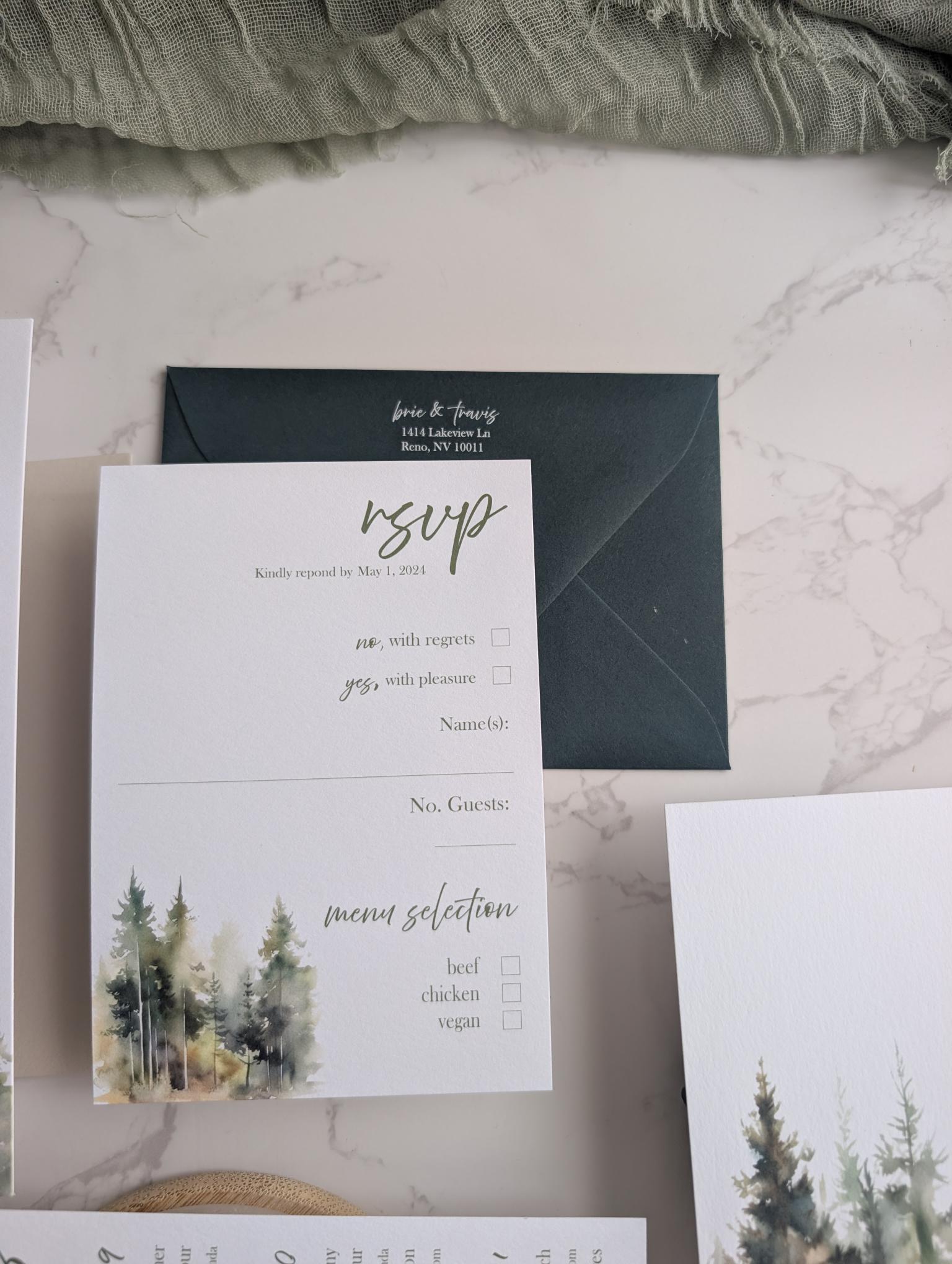 Wedding invitation set with RSVP card and menu on a marble surface