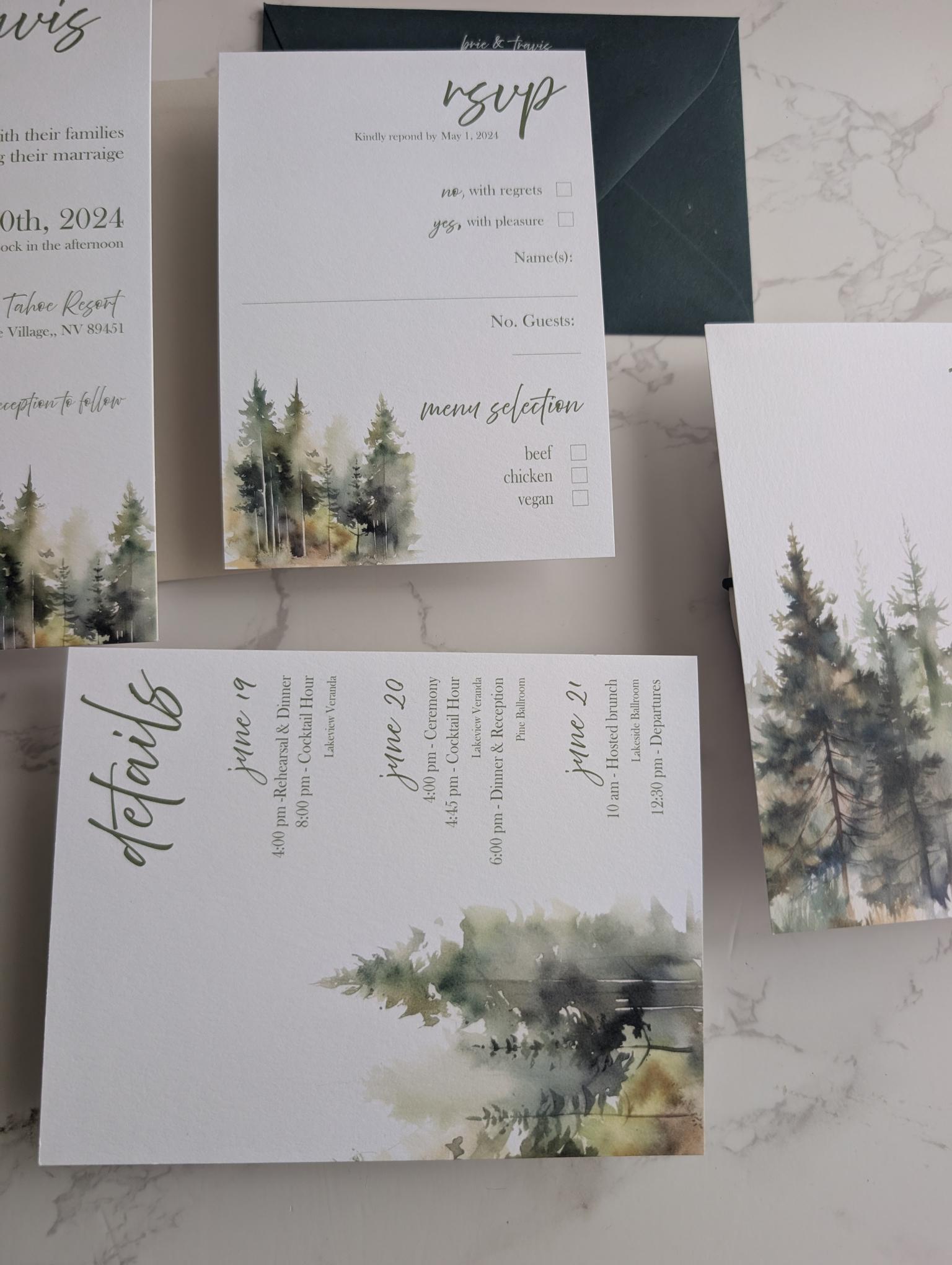 Set of wedding invitations with nature-themed design on a marble surface